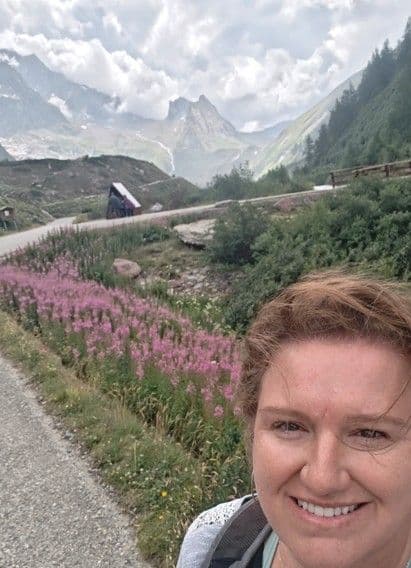 Jules Smith in front of Italian mountains and flowers